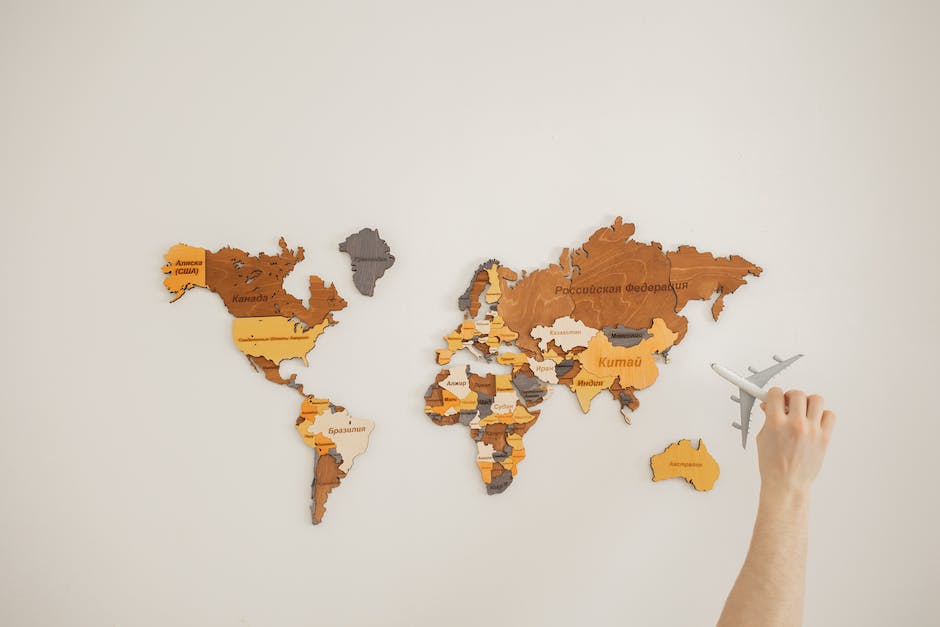 Image of a person holding a travel card with a world map design, representing the concept of travel cards for avid travelers